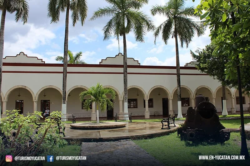 Edificio con arcos, jardines y palmeras en Felipe Carrillo Puerto